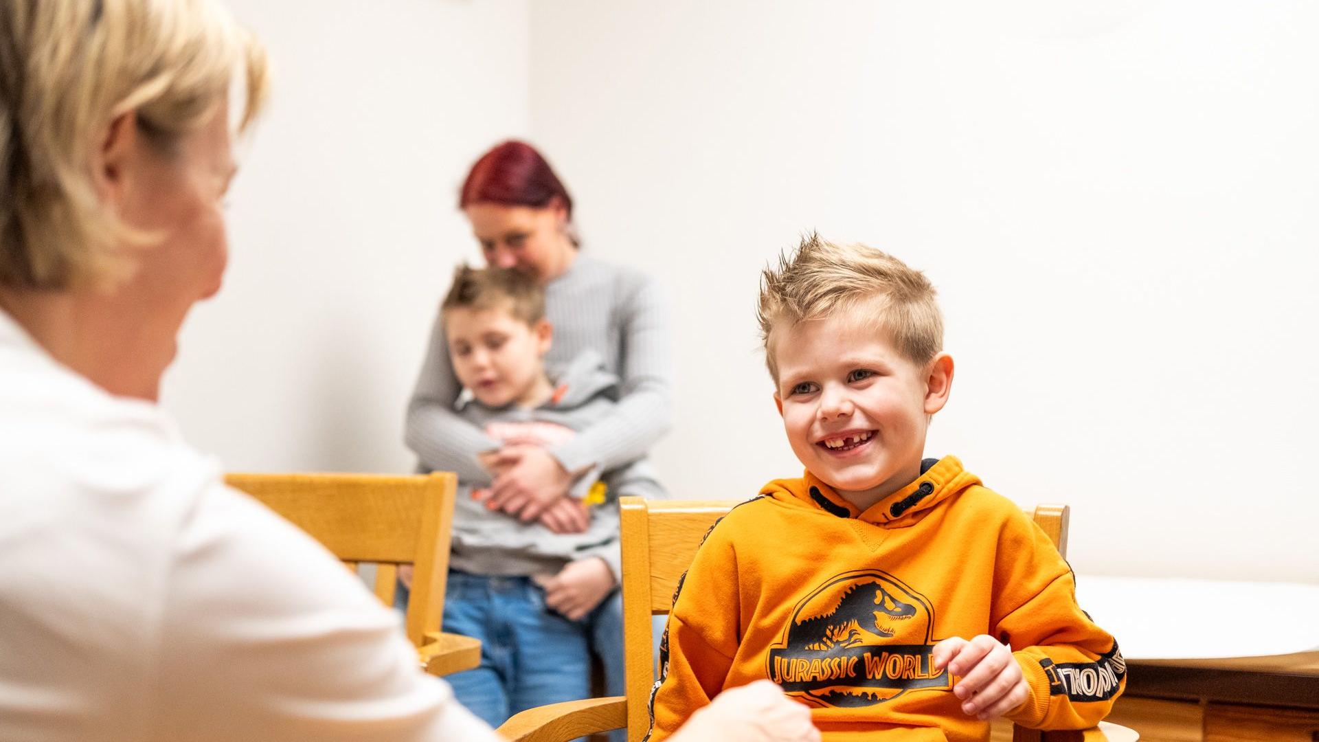 Ein Junge sitzt im Sprechzimmer bei einer Ärztin
